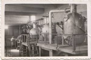 ΑΦΡΟΔΙΤΗ Ο.Ε.Β.Ε. Βιομηχανία Κονσερβών Τοματοπελτέ. Τα καζάνια συμπύκνωσης και ο άξονας μετάδοσης της κίνησης (στον τοίχο). Το συγκρότημα είχε αυτόνομη ηλεκτροπαραγωγή γιά την κάλυψη των αναγκών καθώς η Κως δεν είχε επάρκεια στο εργοστάσιο της ΔΕΗ. Αρχείο Δία Χαραλαμπόπουλου